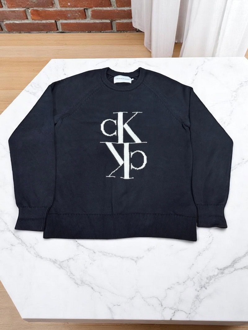 Ropa vintage con logo calvin klein Suéter vintage Calvin Klein en color negro con logo en el centro, estilo clásico y elegante.