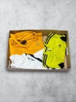 Ropa vintage de fútbol en caja con camisetas de cuero y tejidos deportivos.