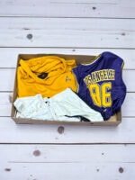 Ropa vintage y cuero en caja misteriosa, ideal para coleccionistas y amantes de la moda retro.